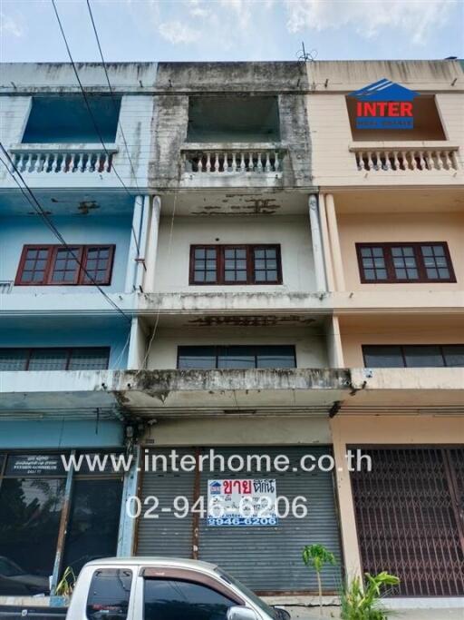 Front view of an aged multistory urban building with signage