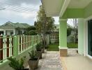 Spacious patio with green railings and a view to a serene garden