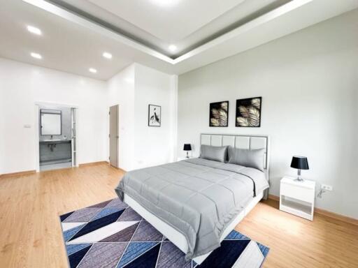 Spacious modern bedroom with hardwood floors and contemporary decor