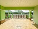 Spacious, covered patio with ceramic tile flooring and vibrant green walls