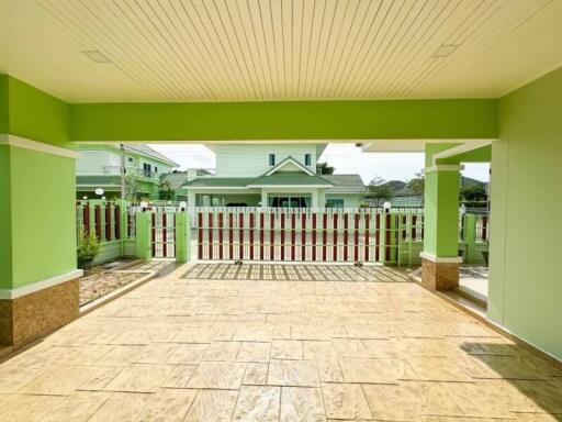 Spacious, covered patio with ceramic tile flooring and vibrant green walls