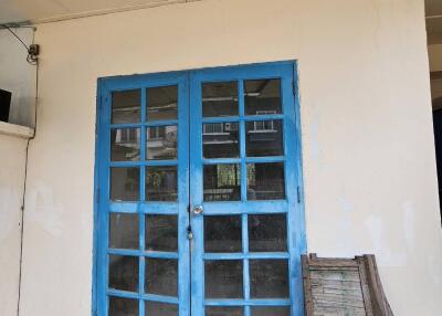 Blue double doors in a building with worn exterior