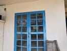 Blue double doors in a building with worn exterior