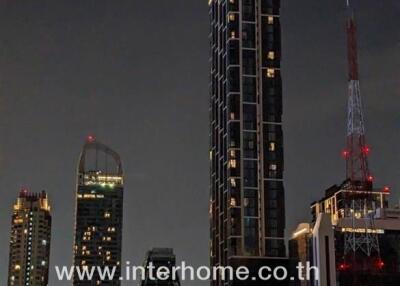 High-rise residential building at night with city skyline