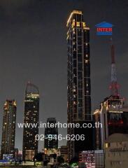 High-rise residential building at night with city skyline