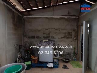 Unfinished indoor space with miscellaneous items and exposed walls