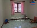 Spacious unfurnished bedroom with large window and light green tiled flooring