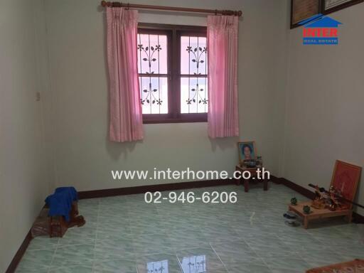 Spacious unfurnished bedroom with large window and light green tiled flooring