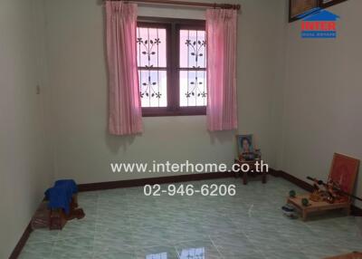 Spacious unfurnished bedroom with large window and light green tiled flooring