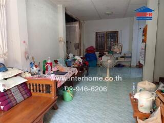 Spacious and cluttered living room with a fan and tiled flooring