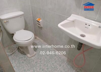 Small tiled bathroom with toilet and sink