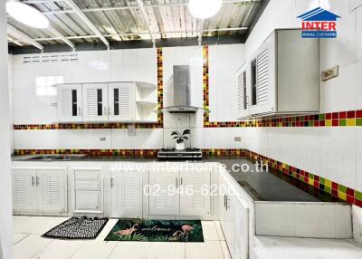 Modern kitchen with white cabinets and colorful tiled backsplash