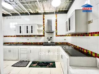 Modern kitchen with white cabinets and colorful tiled backsplash