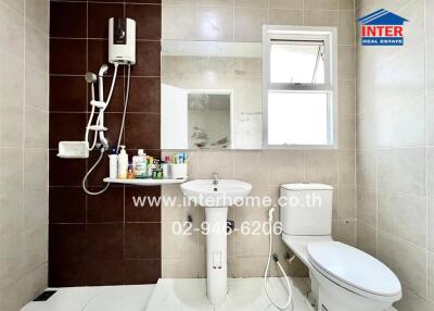 Modern bathroom with wall-mounted shower, white toilet, and pedestal sink