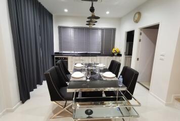 Modern dining room with elegant table set and open plan kitchen