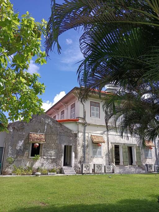 Elegant two-story historic building with a lush green garden