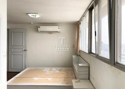 Spacious bedroom with large windows, air conditioning unit, and wooden flooring