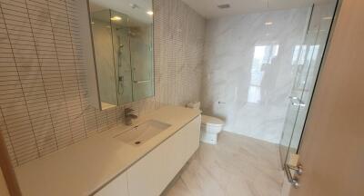 Modern bathroom with glass shower and beige tiles