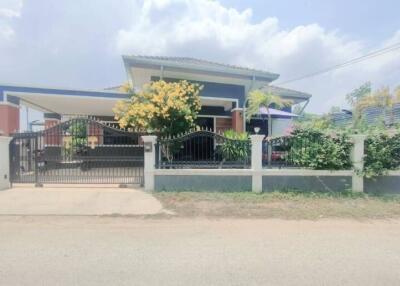 Exterior view of a modern single-family home with a flourishing garden and gated entrance