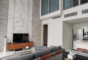 Spacious modern living room with high ceiling and marble wall