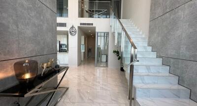 Elegant lobby interior with marble floors and a modern staircase