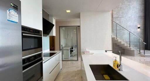 Modern kitchen with integrated appliances and adjoining staircase