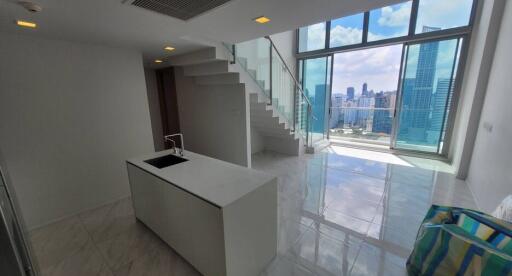 Modern high-rise apartment interior with lustrous tiled flooring, expansive windows offering city skyline views, and a sleek staircase