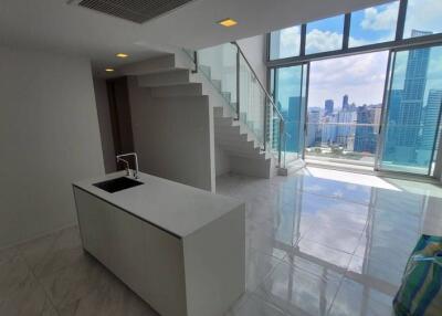 Modern high-rise apartment interior with lustrous tiled flooring, expansive windows offering city skyline views, and a sleek staircase