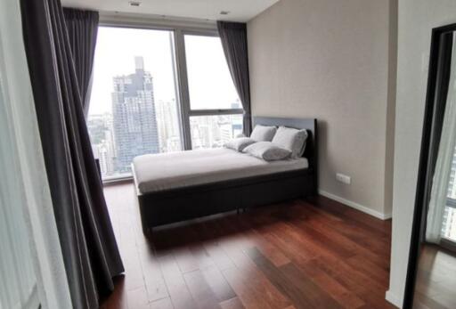 Modern bedroom with city view through large window