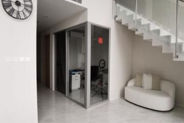 Modern living room with glass partition and staircase