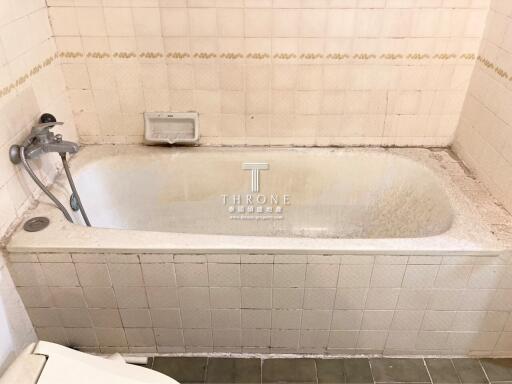Spacious built-in bathtub in need of refurbishment