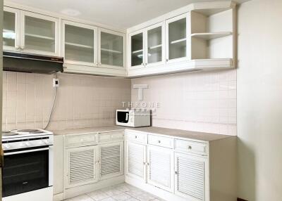 Bright and neatly arranged kitchen with white cabinetry and appliances