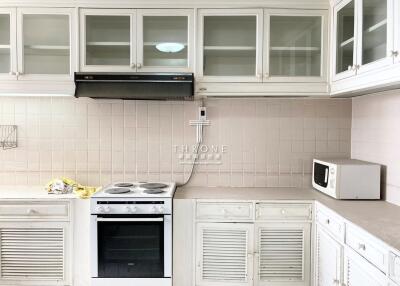 Compact and well-equipped kitchen with white cabinetry and modern appliances