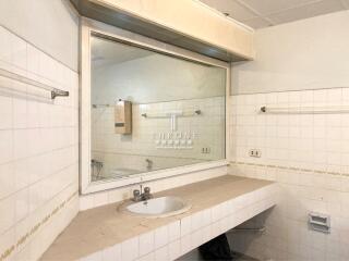 Clean spacious bathroom with large mirror and under-sink storage