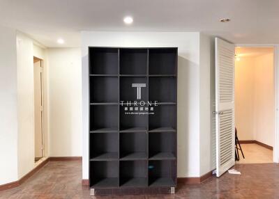 Spacious living room with large shelving unit and wooden flooring