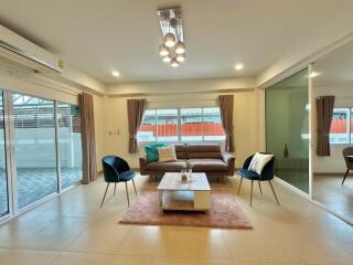 Spacious and well-lit living room with modern furniture and large windows