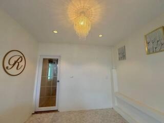 Brightly lit hallway with elegant chandelier and decorative elements