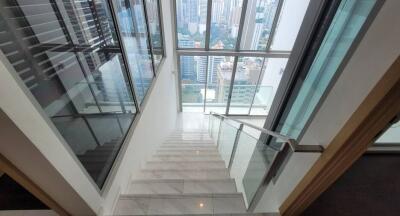 Modern staircase in a high-rise apartment with city view