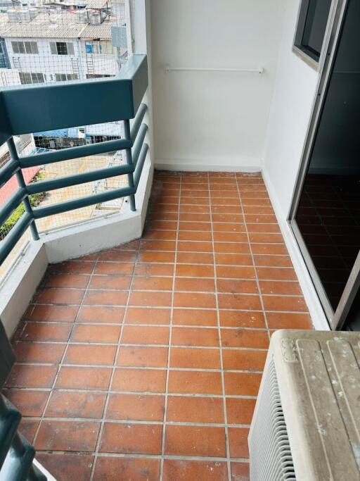 small balcony with terracotta tiles and urban view