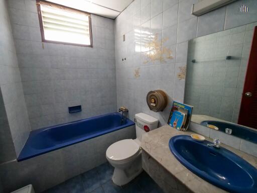 Spacious bathroom with blue fixtures and tiled walls