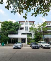 Modern multi-story building facade with parked cars