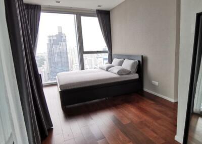 Modern bedroom with expansive city view and hardwood floors