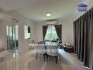 Spacious, well-lit living room with dining area and view of outdoors through glass doors