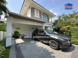 Two-story suburban house with a car parked in the driveway