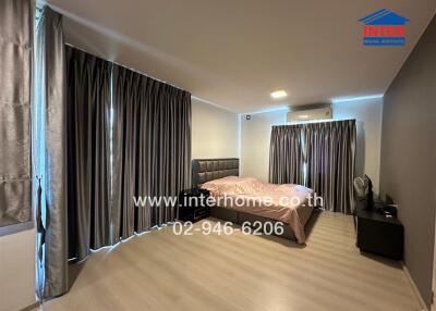 Spacious modern bedroom with large bed and extensive curtains