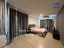 Spacious modern bedroom with large bed and extensive curtains