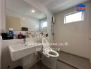 Modern bathroom with white and gray tiles, well-lit with a window