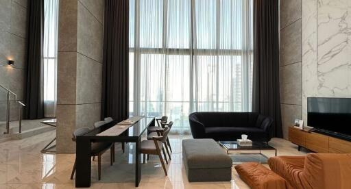 Modern living room in high-rise apartment with expansive windows and stylish furniture