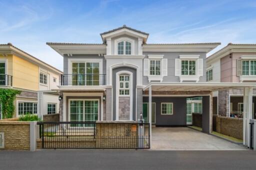 Elegant two-story residential house with secure gate and driveway