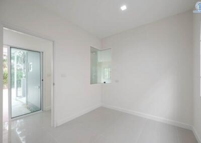 Bright and spacious empty room with large windows and glass door leading to the garden